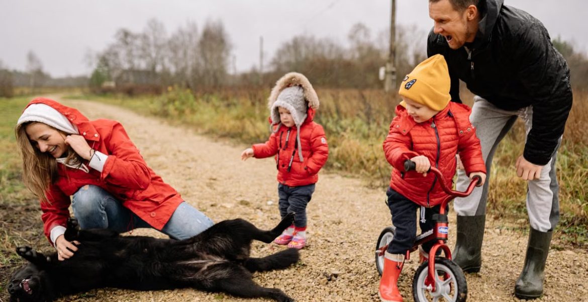 Happy family enjoying quality time outdoors with kids and dog in countryside.